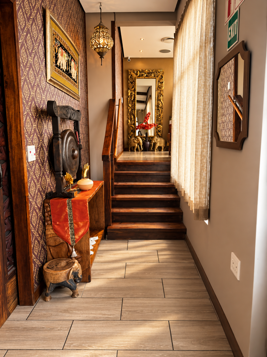 Inside Aiyara Thai Spa: warm wooden stairs, Thai-inspired decor and golden elephant details